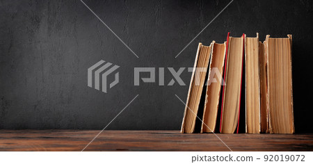 Old books on wooden table and blackboard 92019072