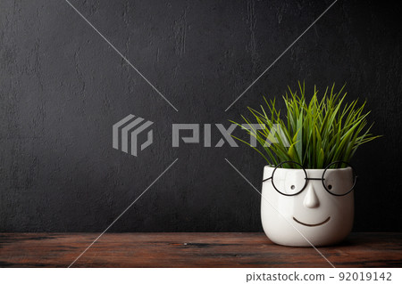 Potted plant with glasses on table and blackboard 92019142