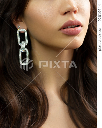 Sexual full lips. Natural gloss of lips and woman's skin. The mouth is closed. Increase in lips, cosmetology. Natural lips. Great summer mood with open eyes. fashion jewelry. Pink lip gloss 92019644