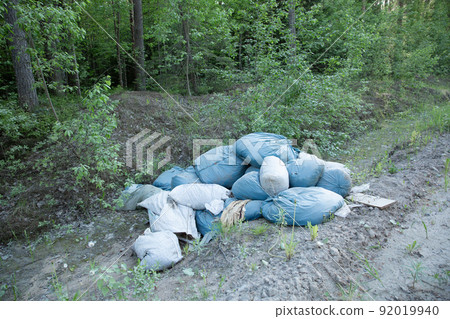 Garbage and pollution. Environmental protection or volunteering for charity, Waste disposal through recycling. Waste is densely deposited in the forest background. Ecological problem concept. 92019940