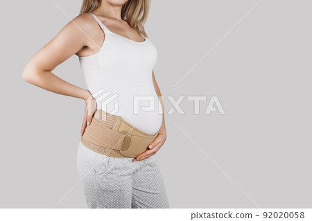 Pregnant woman belly in prenatal pregnancy maternity belt. Orthopedic abdominal support waist, back, abdomen band. Belly brace or band for pregnancy. Horizontal web banner. Torso of pregnant model. 92020058