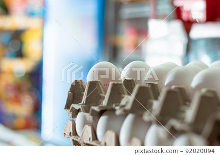 detail view of white chicken eggs placed in a carton. sale of eggs in a grocery store. eggs rich in protein and albumin ready to be sold and consumed in different foods. 92020094