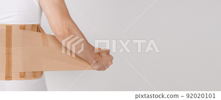 Lumbar brace on the human body isolated on a white background. Trauma of back. Back brace, orthopedic lumbar, support belt for back muscles. Lower back problems health. 92020101