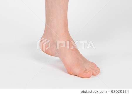 Barefoot and legs isolated on white background. Closeup shot of healthy beautiful female feet. Health and beauty concept. Side view of human foot ream with neutral manicure or pedicure. Sole of foot. Barefoot and legs isolated on white background. Closeup shot of healthy beautiful female feet. Health and beauty concept. Side view of human foot ream with neutral manicure or pedicure. Sole of foot. 92020124