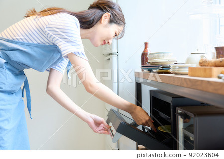 Woman cooking in the microwave Woman cooking in the microwave 92023604