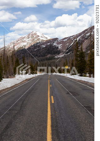 Scenic Road surrounded by Mountains and Trees. 92023781