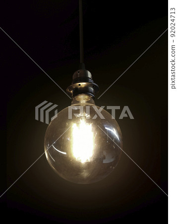 Glowing light bulb on dark background Glowing light bulb on dark background 92024713