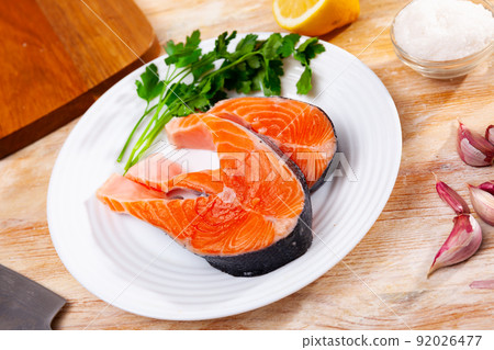 Raw salmon steaks with lemon, parsley, garlic Raw salmon steaks with lemon, parsley, garlic 92026477