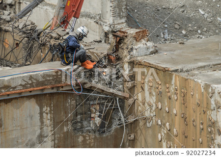 A worker performing gas cutting at a demolition site 92027234