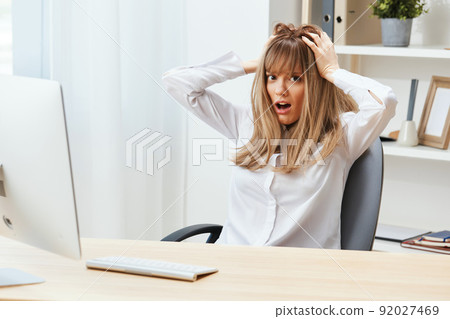 Shocked adorable blonde businesswoman typing answer for client look at camera touch head sitting at workplace in modern office. Unhappy employee work on computer online in support service. Copy space Shocked adorable blonde businesswoman typing answer for client look at camera touch head sitting at workplace in modern office. Unhappy employee work on computer online in support service. Copy space 92027469