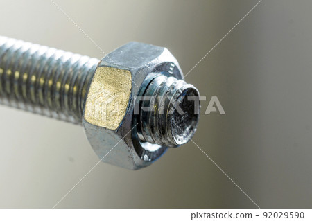 Stainless steel bolts and nuts on a white background. Bolt, washer and nut on a white background. Bolt on a white background. Bolt screw nut washer carving. 92029590