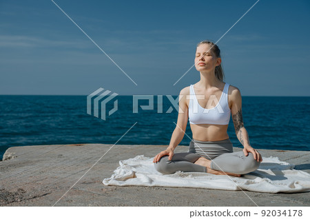 Yoga practice and meditation in nature. Woman practicing near Black sea. Yoga practice and meditation in nature. Woman practicing near Black sea. 92034178