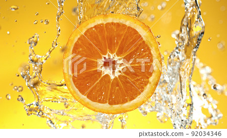Slice of orange with water splashes on colored background. 92034346
