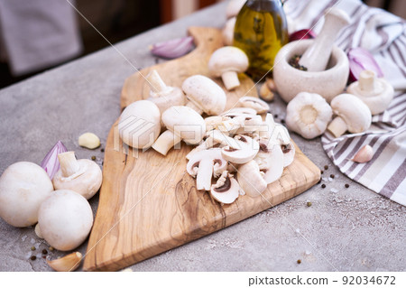 champignon mushrooms on wooden cutting board at domestic kitchen 92034672