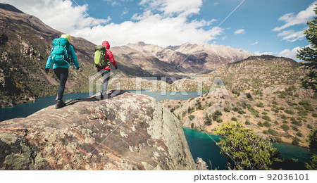 Two women backpackers hiking in beautiful winter mountains Two women backpackers hiking in beautiful winter mountains 92036101
