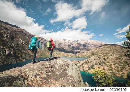 Two women backpackers hiking  in beautiful winter mountains 92036102