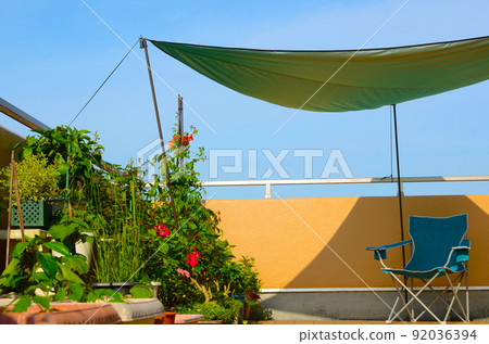 On a hot summer day, put your shade and camp chair on your balcony and feel like camping at home 92036394