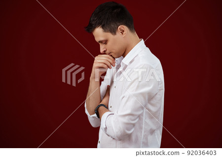 man holding arms folded, touching chin with hand 92036403