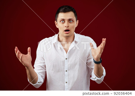 surprised shocked brunette man in white shirt 92036404