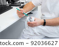 hands of a dentist close-up. dentist with a pencil shows jaw defects on a plaster cast. 92036627