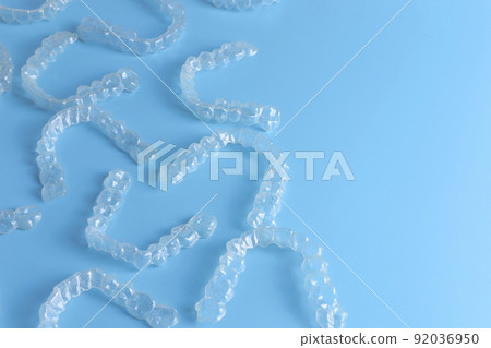 Invisalign transparent brackets or braces on blue background with copy space 92036950