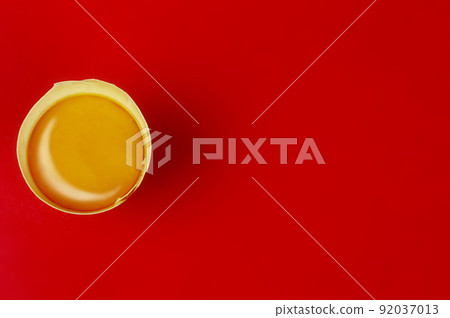 Raw egg yolk on red background with copy space. B 92037013
