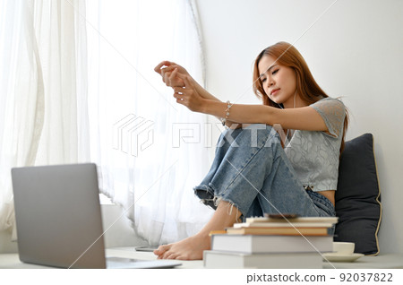 Sad and unhappy young Asian woman listening a sad song with her earphones, feeling upset 92037822