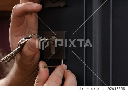 Installation of a door lock, a carpenter installs a door lock in a door, work close-up. Installation of a door lock, a carpenter installs a door lock in a door, work close-up. 92038268