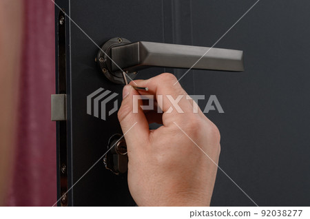 Hex key and installation of door lock and handle, close-up of installation work. 92038277