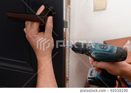 Installation of a door handle on interior doors, carpentry work with doors. Installation of a door handle on interior doors, carpentry work with doors. 92038290
