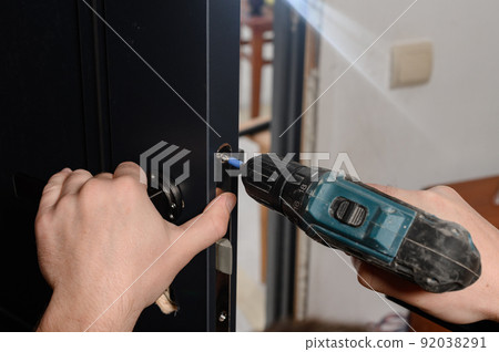 Installation of a door handle on interior doors, carpentry work with doors. Installation of a door handle on interior doors, carpentry work with doors. 92038291