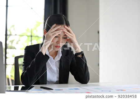 Young Asian businesswoman thoughtful and serious, pensively thinking about her financial plan Young Asian businesswoman thoughtful and serious, pensively thinking about her financial plan 92038458