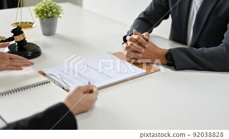 A professional female lawyer counsels and meets with her client to sign a contract agreement. A professional female lawyer counsels and meets with her client to sign a contract agreement. 92038828