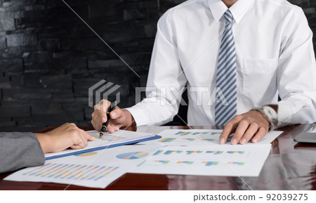 Two business leaders talk about charts, financial graphs showing results are analyzing and calculating planning strategies, business success building processes 92039275