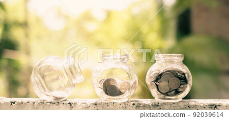 Retirement savings concept. bottle glass and coins with green nature background and copy space 92039614