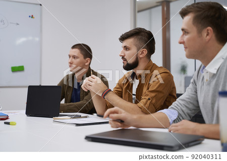 Making great decisions. Team members discuss software features during the meeting in IT office 92040311