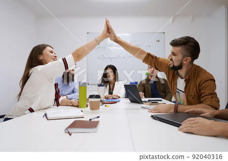 Happy team giving hightfive. Celebrating success with hi five. Coworkers friends touching hands after completed the work perfectly. 92040316