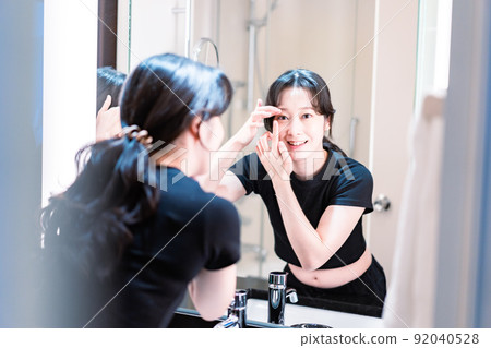 A young woman wearing a contact lens A young woman wearing a contact lens 92040528