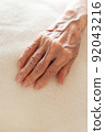 Senior woman's hand placed on a blanket 92043216