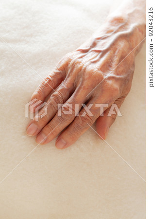 Senior woman's hand placed on a blanket Senior woman's hand placed on a blanket 92043216