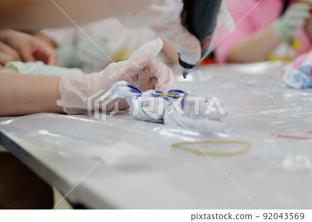 Creating prints on a T-shirt using the tai dai technique.T-shirt in the style of Tai dai Creating prints on a T-shirt using the tai dai technique.T-shirt in the style of Tai dai 92043569