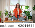 Young female freelancer meditate at workplace in lotus position, feeling zen, no stress, calm concept. 92044634
