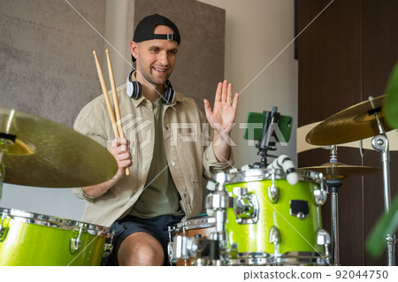 Man records drum lesson on phone and shows playing technique Man records drum lesson on phone and shows playing technique 92044750