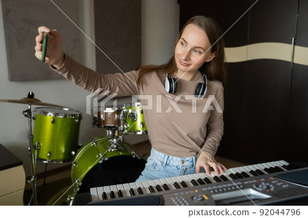 Lady talks on phone and shows on video playing synthesizer Lady talks on phone and shows on video playing synthesizer 92044796