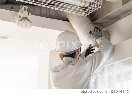 Back view of a worker inspecting a duct Back view of a worker inspecting a duct 92044845