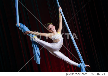 Circus artist acrobat performance on canvases. The girl perform acrobatic elements in the air. 92046171