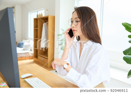 一個女人在辦公桌前打電話 92046911