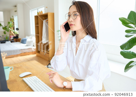 一個女人在辦公桌前打電話 92046913