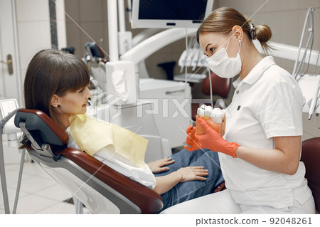 Woman in a dental chair. Dentist teaches proper care.Beauty treats her teeth 92048261
