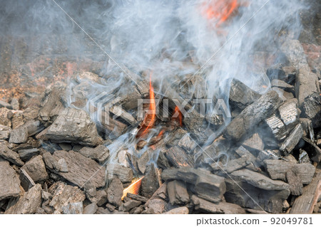 Using flaming hot charcoal to cook barbecue on a barbecue grill Using flaming hot charcoal to cook barbecue on a barbecue grill 92049781